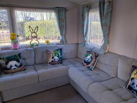 A living room with a sofa and cushions at Wl34 Caravan Haggerston Castle Private Decking Haggerston