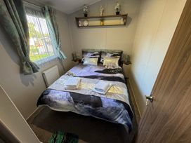 A bedroom with a bed and shelf at Wl34 Caravan Haggerston Castle Private Decking Haggerston