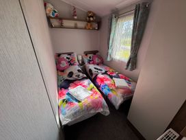 A bedroom with two beds and a shelf at Wl34 Caravan Haggerston Castle Private Decking Haggerston