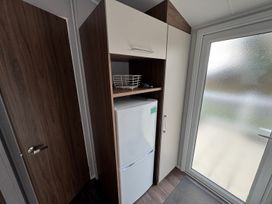 A fridge and shelf in a hallway at Wl34 Caravan Haggerston Castle Private Decking Haggerston