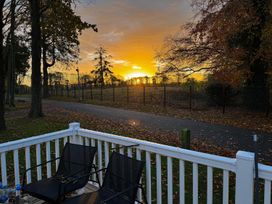 An outdoor area with chairs and trees during sunset at Wl34 Caravan Haggerston Castle Private Decking Haggerston