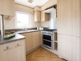 A kitchen with a sink and oven at Caravan - Sleeps 8 - Parking, Northampton