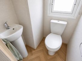 A bathroom with a toilet and sink in Caravan - Sleeps 8 - Parking, Northampton