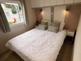 A bedroom with a bed and window at Caravan - Sleeps 8 - Parking in Northampton