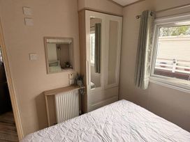 A bedroom with a bed and wardrobe at Caravan - Sleeps 8 - Parking in Northampton