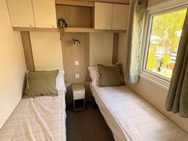 A bedroom with two beds and a window at Caravan - Sleeps 8 - Parking Northampton
