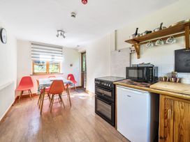 A kitchen with a table and chairs at 3-Bed Barn Eco-Lodge on the Tarka trail East Yarde near Great Torrington