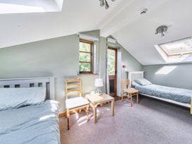 A bedroom with two beds and a table at 3-Bed Barn Eco-Lodge on the Tarka trail East Yarde near Great Torrington