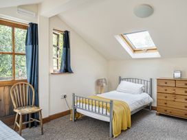 A bedroom with a bed and dresser at 3-Bed Barn Eco-Lodge on the Tarka trail East Yarde near Great Torrington