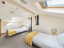 A bedroom with two beds and a lamp at 3-Bed Barn Eco-Lodge on the Tarka trail East Yarde near Great Torrington