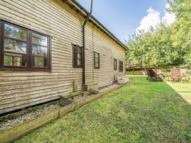 A garden area with a wooden building and seating at 3-Bed Barn Eco-Lodge on the Tarka trail, East Yarde near Great Torrington