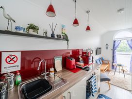 A kitchen with appliances and a dining area at 1 Bed Cottage - Sleeps 2 - Wifi in Malpas near Truro