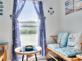 A living room featuring a window with curtains and a sofa with cushions at 1 Bed Cottage - Sleeps 2 - Wifi in Malpas near Truro