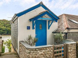 A front entrance with blue door and stone wall at The Beach Hut in Malpas near Truro