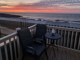 A patio with chairs and a table overlooking the ocean at Seafront Caravan - Golden Sands - 6 Berth by Your Away Stays in Kinmel Bay