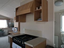 A kitchen with stove and kitchen cabinet at Seafront Caravan - Golden Sands - 6 Berth by Your Away Stays in Kinmel Bay