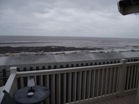 A view of the sea and rocks from a deck at Seafront Caravan - Golden Sands - 6 Berth by Your Away Stays in Kinmel Bay
