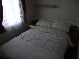 A bedroom with a bed and pillows at Seafront Caravan - Golden Sands - 6 Berth by Your Away Stays, Kinmel Bay