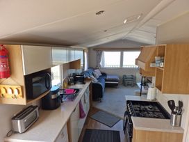 A kitchen with appliances and a couch at Seafront Caravan - Golden Sands - 6 Berth by Your Away Stays, Kinmel Bay