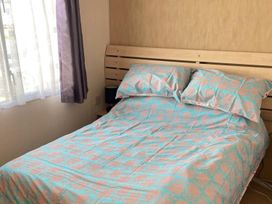 A bedroom with a bed and pillows at 4 Bed Lodge Sleeps 8 - Pets & WiFi Free Parking in Ingoldmells