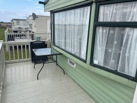 An outdoor patio area with a table and chairs at a lodge in Ingoldmells