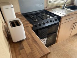 A kitchen with a gas stove and a toaster at 4 Bed Lodge Sleeps 8 - Pets & Free Parking in Ingoldmells