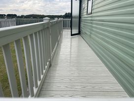An outdoor balcony with railings and a door at 4 Bed Lodge Sleeps 8 - Pets & WiFi Free Parking in Ingoldmells