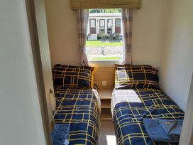 A bedroom with two beds and a window at Ye Old'e Man - Sleeps 6 & Pet Friendly Near Flookburgh