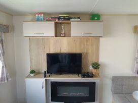 A living room with a television and shelf in Ye Old'e Man - Sleeps 6 & Pet Friendly Near Flookburgh