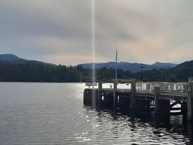 A pier over water with boats in the distance at Ye Old'e Man - Sleeps 6 & Pet Friendly Near Flookburgh