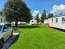 An outdoor area with a car, table, and holiday homes at Ye Old'e Man - Sleeps 6 & Pet Friendly near Flookburgh