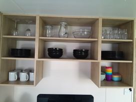 A kitchen shelf with various glassware and dishware at Ye Old'e Man - Sleeps 6 & Pet Friendly, Near Flookburgh