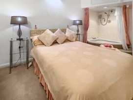 A bedroom with a bed and a whirlpool bath at Apartment Sleeps 2 with Parking, Pets Welcome Watermillock near Pooley Bridge