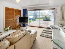A living room with a sliding door and television at Apartment Sleeps 2 with Parking, Pets Welcome in Watermillock near Pooley Bridge