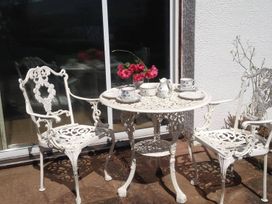 A table with chairs and cups at an outdoor seating area at Apartment Sleeps 2 with Parking, Pets Welcome, Watermillock near Pooley Bridge