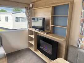 A living room with a TV and fireplace at Caravan Sleeps 5 - Decking, Parking, Pet Friendly in Blackpool
