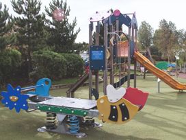 Playground equipment with slide and spring riders in an outdoor play area