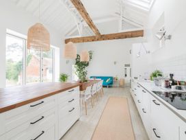 A kitchen with an island and dining setup at Simple Coastal Luxury near Southwold