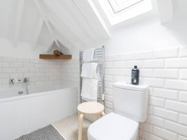A bathroom with a bathtub, toilet, and towel rack at Simple Coastal Luxury near Southwold sleeps 10 near Southwold