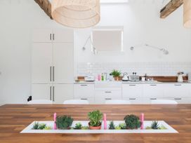 A kitchen with wooden table and plants at Simple Coastal Luxury near Southwold sleeps 10 Near Southwold