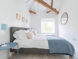 A bedroom with two beds and a large window at Simple Coastal Luxury near Southwold sleeps 10 near Southwold
