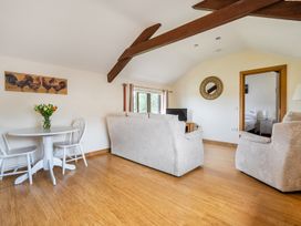 A living room with a sofa, table, and television at The Shippon, Breathtaking Views, Private Hot Tub Winkleigh