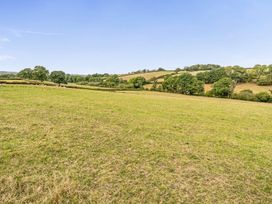 A grassy field with trees and hills at The Shippon, Breathtaking Views, Private Hot Tub Winkleigh