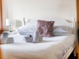 A bedroom with a bed, pillows, cushion, and lamp at The Shippon, Breathtaking Views, Private Hot Tub, Winkleigh