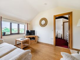 A living room with a sofa and a table at The Shippon, Breathtaking Views, Private Hot Tub, Winkleigh