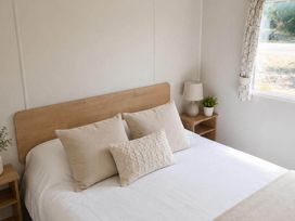 A bedroom with a bed and bedside table at Billing Aquadrome Holiday Park - 2 Bedroom, Silver, Northampton