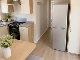 A kitchen with a fridge and stove at Billing Aquadrome Holiday Park - 2 Bedroom, Silver, Northampton