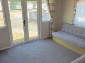 A lounge with double doors and a sofa at Billing Aquadrome Holiday Park - 2 Bedroom, Silver, Northampton