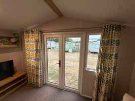 A living room with a television and curtains at Billing Aquadrome Holiday Park - 2 Bedroom, Silver, Northampton