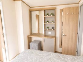 A bedroom with a mirror and shelves at Tattershall Lakes - Hot Tub - Sleeps 6 - Pets, Tattershall